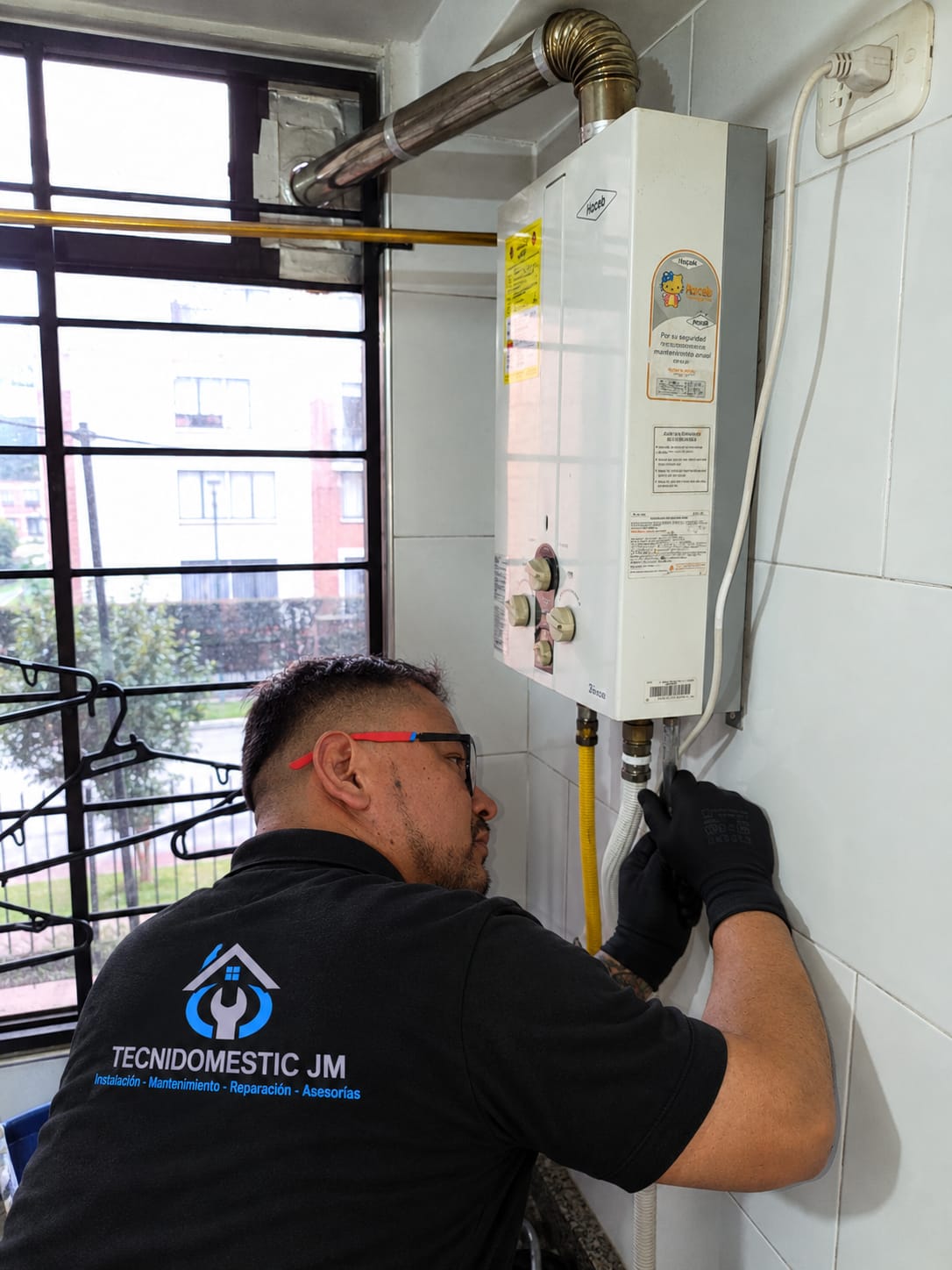 Técnico de Tecnidomestic JM realizando mantenimiento de calentador a gas en Bosa