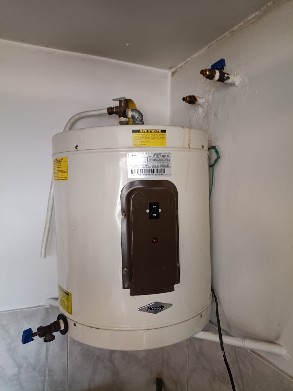 Técnico ajustando conexiones de gas en instalación de calentador a domicilio